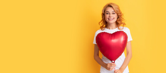 cheerful redhead woman with red heart balloon. charity and donation. Beautiful woman isolated face portrait, banner with mock up copy space.