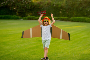 Boy kid dreams of becoming a pilot. Kid pilot aviator with with paper wings dreams of traveling in...