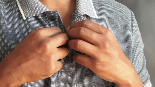 Man buttoning his shirt close up