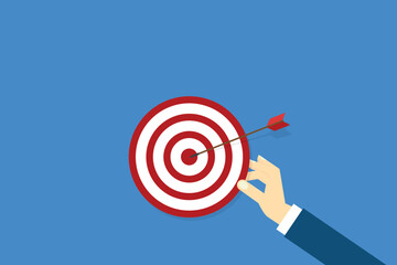 Hand holding a target, showing a goal. Red arrow hits the center. Business challenge failure and success concept.	