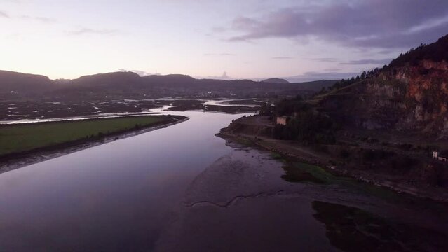 Evening magneta sky over low tide coastal mudflats estuarine landscape AERIAL 