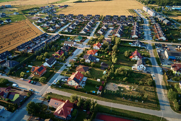 Residential houses in small town near agricultural field, bird eye view. Aerial view of European...