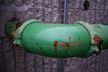 Large green sewer piping ninety degree corner piece.