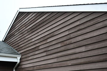 Un-painted wooden siding with pitched roof.