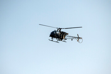 Fototapeta na wymiar Combat helicopter is flying on isolated blue sky.