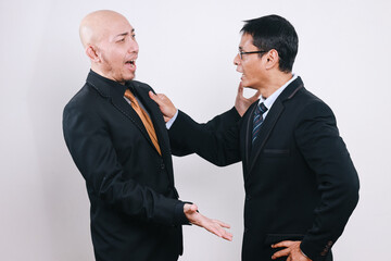 Two Asian businessmen have disagreement and conflict, arguing over business matters.