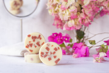 Obraz na płótnie Canvas handmade natural soap bars, handmade rose clay soap on white background with pink flowers.