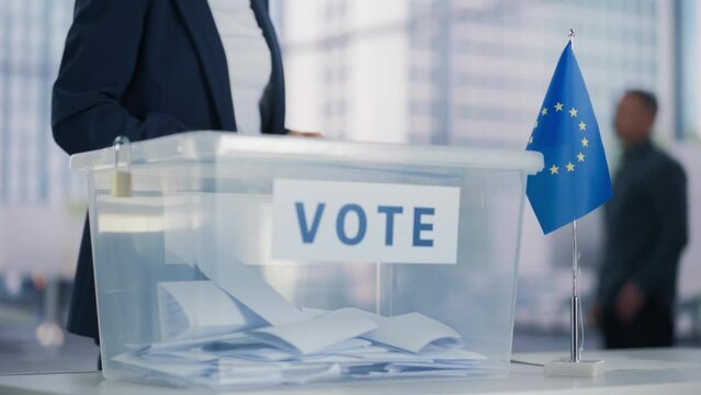 Adult Caucasian Female Putting Her Voting Ballot into a Sealed Box at a Modern Polling Station. Anonymous European Woman Exercising Civic Duty on Elections Day in the European Union Democracy