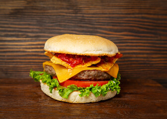 Burger, sandwich, hamburger with meat cutlet, chips, tomato and cheese on a wooden background