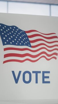 Vertical Screen: Establishing Footage of an American Flag on a Voting Booth in an Empty Polling Station in a Financial District. Elections Day Concept with Patriotic United States of America Visuals