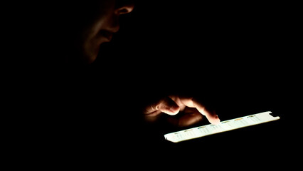 Finger touching the phone screen in the dark