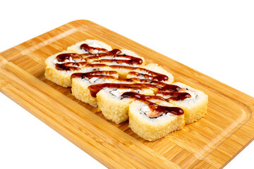 Japanese sushi roll fried with salmon and teriyaki sauce on a wooden board, isolated.