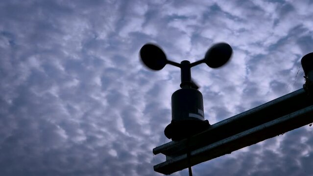 Silhouette of anemometer cup on cloudy sky background, old and rusty wind speed indicator, measure instrument of direction and velocity of wind. 4K
