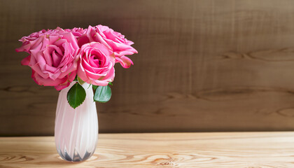 pink rose in vase on wood background with copy space; home interior and beauty composition