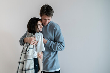 A smiling couple is bundled up in warm, comfortable clothes, expressing closeness and shared...