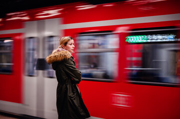 Catching the Metro Moment, Woman with smartphone as the train arrives at the subway platform