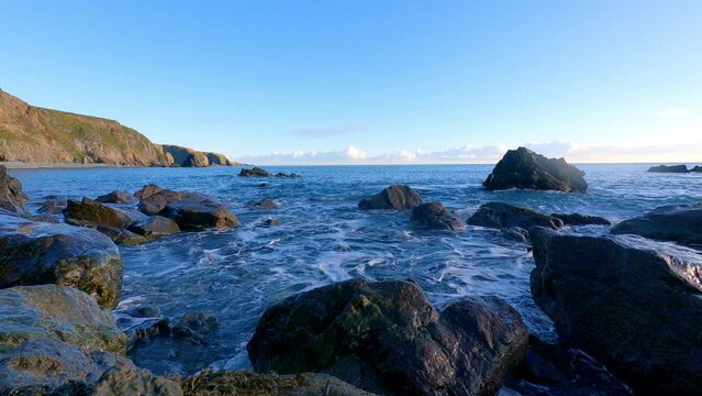 Timelapse rocky beach incoming tides blue Skys and cliffs Copper Coast Waterford Ireland beauty in nature