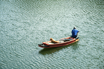 Fisherman in boat with dog on the river