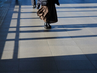 冬の繁華街の道路で歩く一人の女性の足の姿