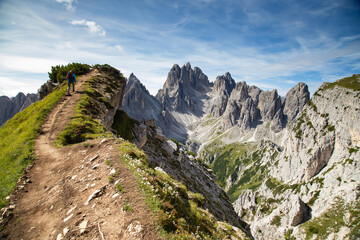 Fototapeta premium Stunning view of a tourist on the top of a hill enjoying the view of the Cadini di Misurina
