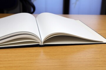 Diario aperto con una pagina vuota sul tavolo come sfondo sulla finestra dell'appartamento.
