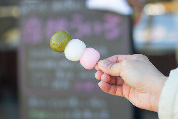 Close up of a sanshoku dango (Three Colored Dumplings) skewer. Focus on dango, blurred background