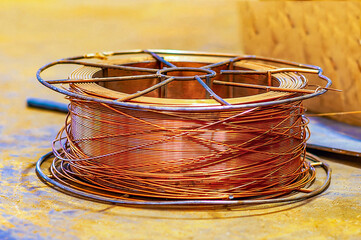 Copper wire spool in selective focus in a factory workshop.