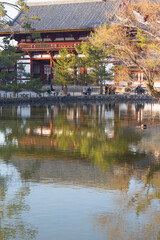 Fototapeta premium Close up of Todaiji Temple and its negative image on lake in Nara in Winter, Japan. Vertical image