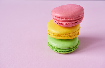 Colorful macaroons on a pink background. Copy space.