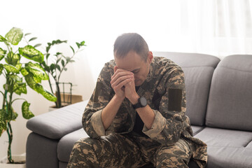 A distraught soldier covering his face, possibly suffering from shell shock or Post Traumatic...