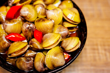 a bowl of clams marinated in soy sauce and chili