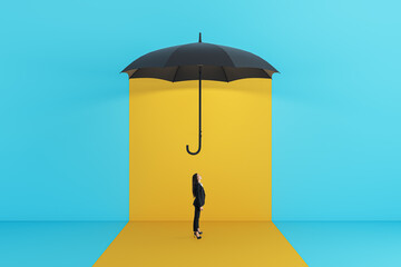 Side view of young businesswoman standing under red umbrella on yellow background. Protection and...