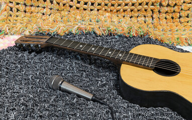 Acoustic retro guitar and microphone recording sound. Musical string instrument on soft cloth.