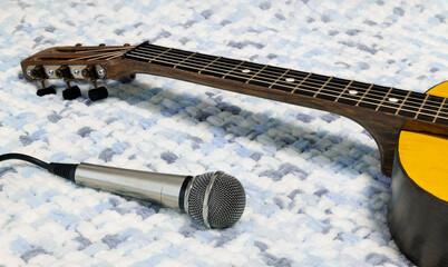 Acoustic guitar and microphone. Musical string instrument on soft cloth. Sound recording concept.