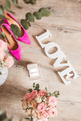 Accessories for bride in wedding day. Pink shoes with wedding rings and a flowers bouquet for bride ceremony time. Love concept