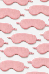 Minimal style pattern from pink sleep masks on white background. Trend Colored fashion eye masks...