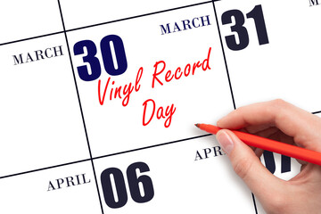 March 30. Hand writing text Vinyl Record Day on calendar date. Save the date.