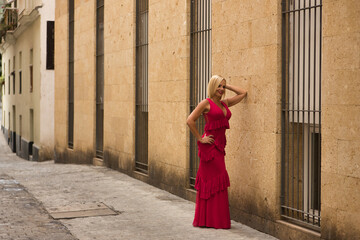 Mature woman, beautiful, blonde, wearing a pink flamenco suit with ruffles and polka dots, happy...