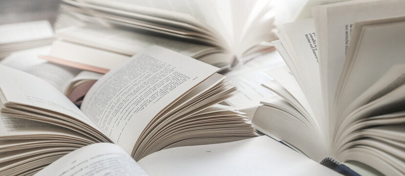 stack of books, close up. Open book on the table in library. Back to school concept. Open book on table with blur bookshelf background