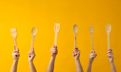 Cutlery in women's hands, on a colored background.