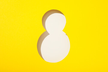 Number eight cut out of paper on a yellow background