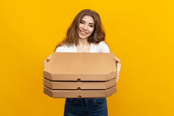 Photo that perfectly represents your restaurant's delivery service. This image of a woman holding pizza boxes on a yellow background is just what you need