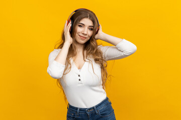 A stunning young female immerses herself in music as she listens to it with headphones, surrounded...