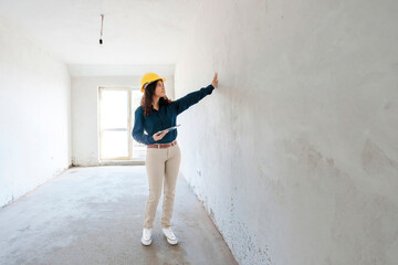 Architect holding tablet PC examining wall at site