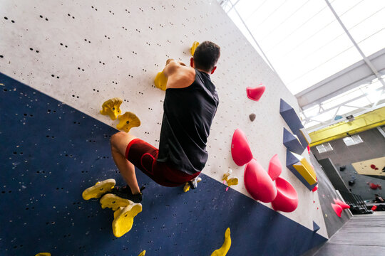 Athlete climbing on boulder wall