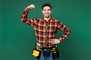 Young employee laborer handyman man wear red shirt show hand biceps muscles demonstrate power...