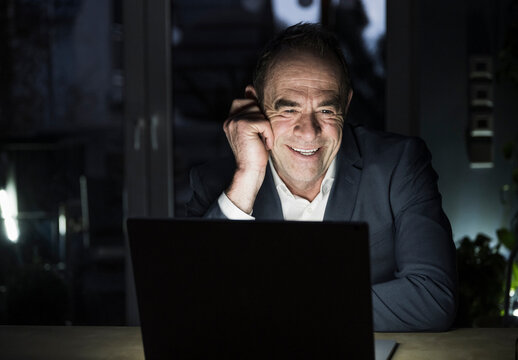 Happy Freelancer Talking On Video Conference Through Laptop At Home Office