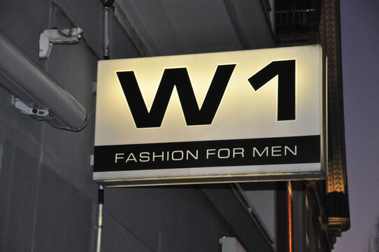 W1 fashion for men: Leuchtreklame an der Au&szlig;enfassade f&uuml;r Herrenmode in Vechta.
