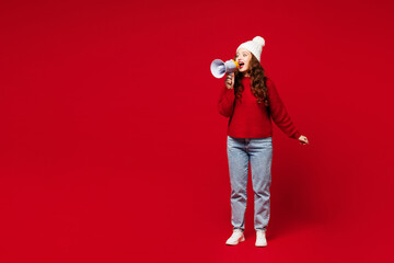 Full body young woman wears knitted sweater white hat casual clothes hold in hand megaphone scream...