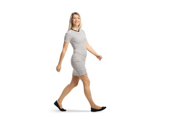 Fototapeta na wymiar Full length shot of a casual young woman walking and smiling